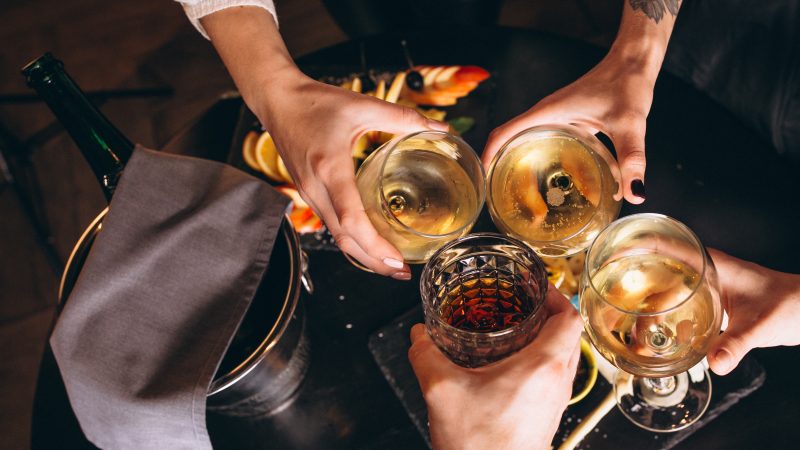 Gros plan sur les mains d'un groupe de personnes qui trinquent